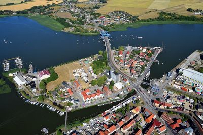 High angle view of buildings by sea in city