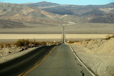 Empty road leading towards mountains