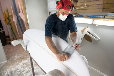 Surfboard modeling workshop - man perfecting the modeling of a surfboard