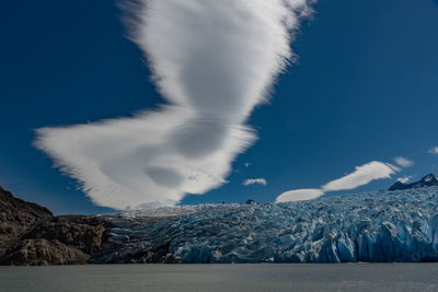 Scenic view of snowcapped mountains by sea against sky