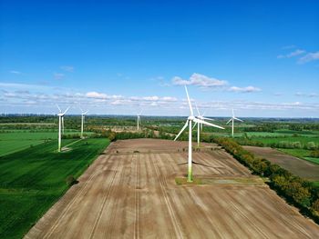 Railroad track on field against blue sky