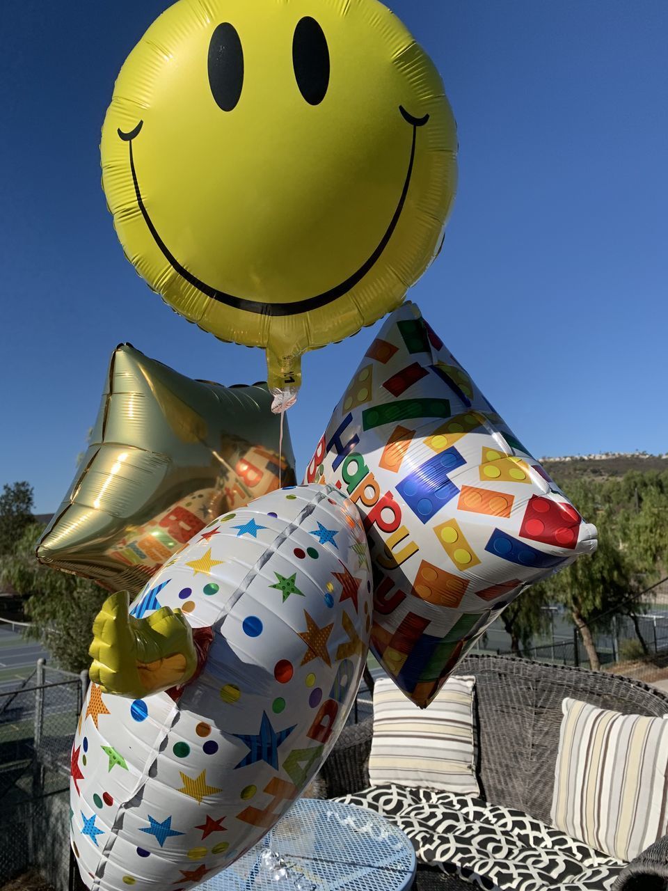 MULTI COLORED BALLOONS AGAINST CLEAR BLUE SKY