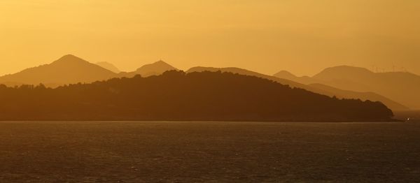 Scenic view of silhouette mountains against sky during sunset