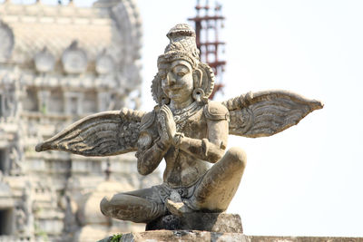 Statue of garudalwar against temple. 