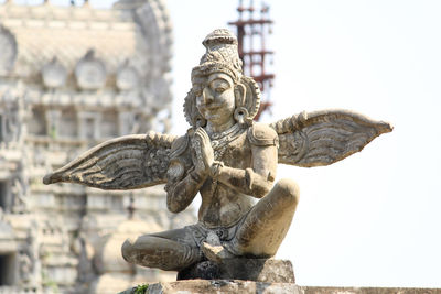 Statue of angel against old building