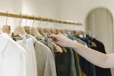 Hand of woman on coathanger at store