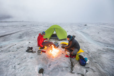 Overhead view of two mountaineers camping on glacier.