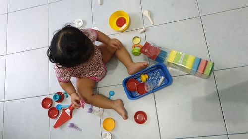 High angle view of girl playing with toy on floor