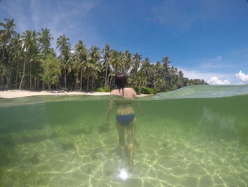 Rear view of man standing in water