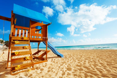 Lifeguard hut on beach against sky