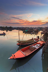 Fishing boats in sea at sunset