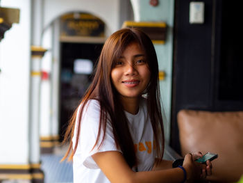 Portrait of smiling girl holding mobile phone