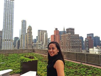 Portrait of smiling woman against urban skyline