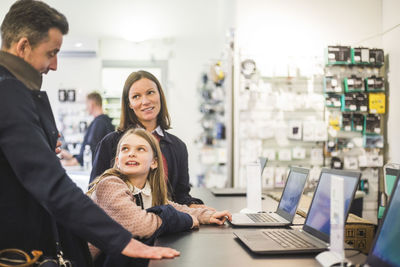 Family discussing while standing in computer store