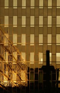 Modern building against sky at sunset