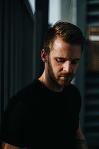 Portrait of young man standing at home