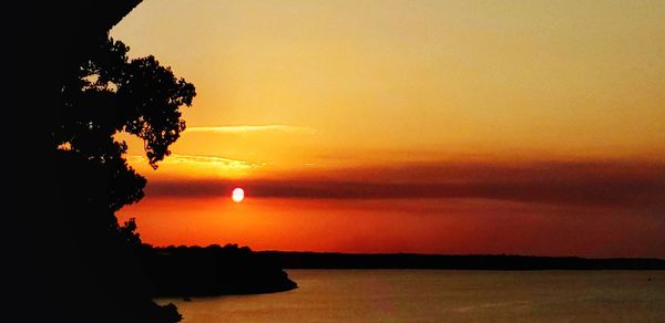 Scenic view of sea against romantic sky at sunset