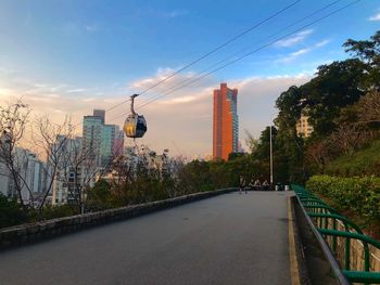 Road by buildings against sky