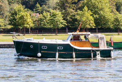 Boats moored on lake against trees