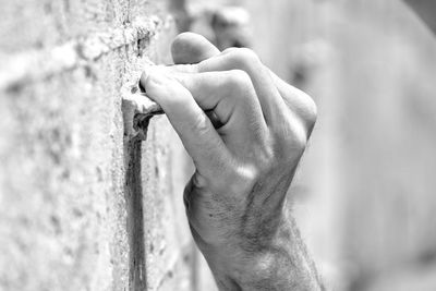 Close-up of man hand against wall