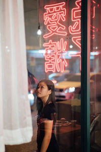 Woman standing by window at store