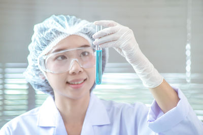 Young female scientist examining chemical in test tube at laboratory