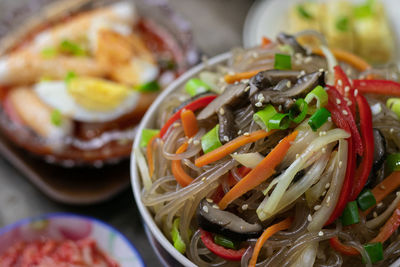 Close-up of vegetables in bowl on table, japxhae and tteokbokki