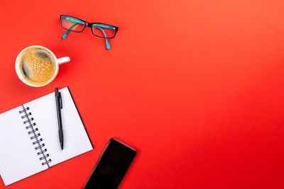 Directly above shot of coffee on table against red background