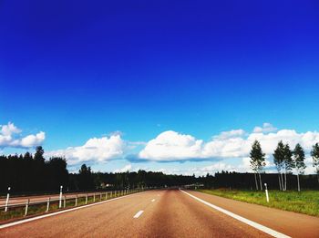Empty road with trees in background