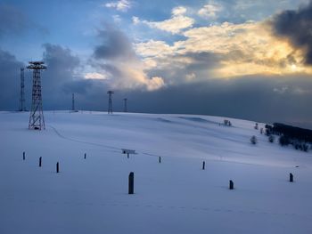 Transmission towers in the mountains during winter on a cloudy day