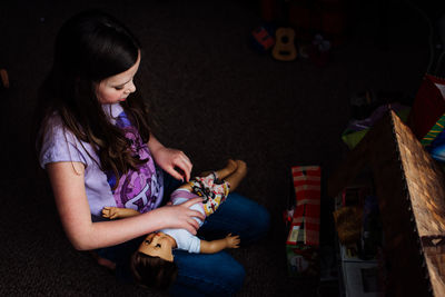 Girl playing doll at home