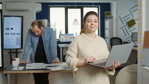 Portrait of businesswoman using laptop at office