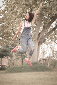 Portrait of young woman exercising on field