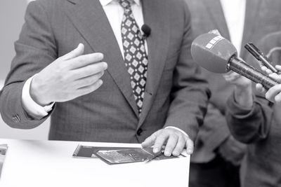 Microphone in focus, news or press conference or media interview with businessman