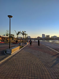 People on street in city against clear sky