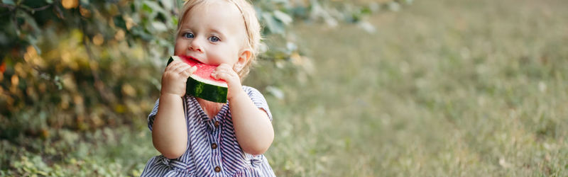 Portrait of cute girl eating watermelon outdoors