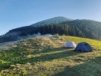 Tent on field by mountain against sky
