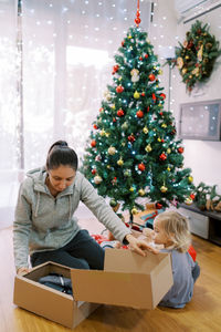 Portrait of smiling girl opening christmas tree