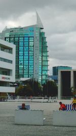 View of modern office building against cloudy sky