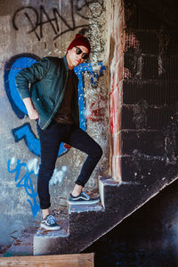 Young man standing against graffiti wall