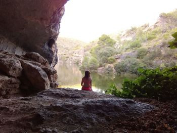 Rear view of man on rock against trees