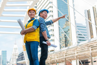 Low angle view of man standing against building in city