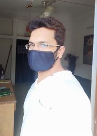 Portrait of young man standing at home