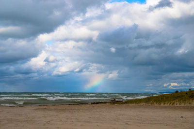 Scenic view of beach against storm clouds