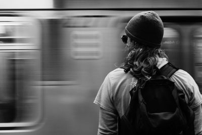 Rear view of man standing by train at railroad station