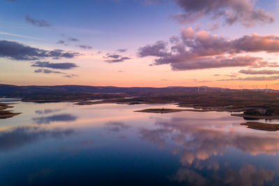 Drone aerial view of a lake reservoir of a dam with reflection on the water in sabugal, portugal