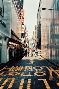 People walking on street amidst buildings in city