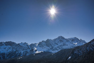 Scenic view of snowcapped mountains against clear blue sky