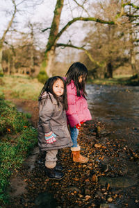 Full length of girl standing against tree