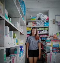 Portrait of young woman standing in store